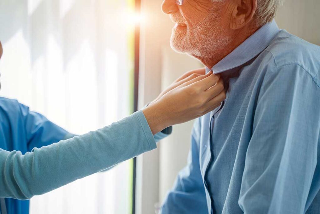 Older adults doing gentle exercises together in a bright assisted living activity room.