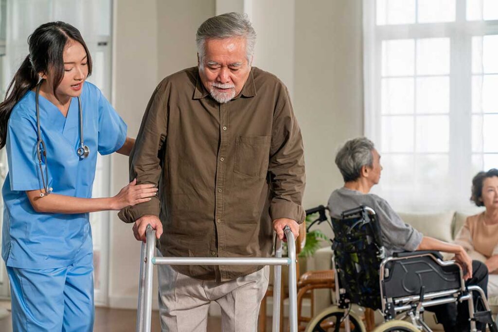 A social worker having a friendly conversation with an older adult in a comfortable communal lounge.